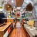 Airstream interior with gray sofa and wood TV stand