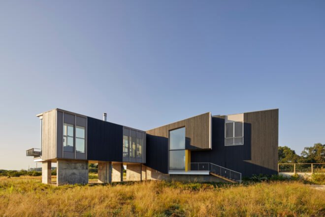 modern home sitting above expansive marshland