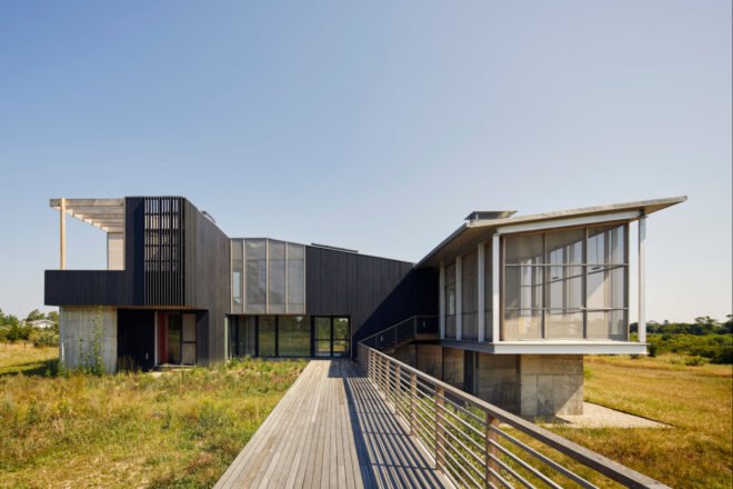 long black home elevated above land