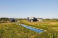 large pool surrounded by expansive green fields