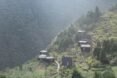black wood cabins of different shapes and sizes on a green mountain