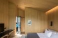 wood-lined bedroom with gray bed