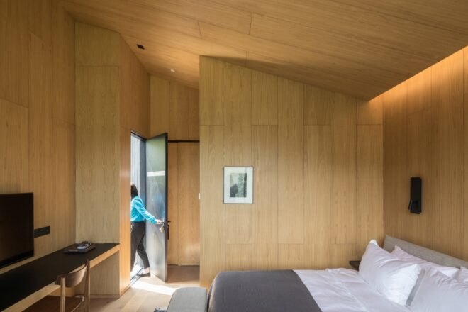 wood-lined bedroom with gray bed