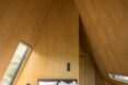 wood-lined bedroom with steeply pitched ceiling
