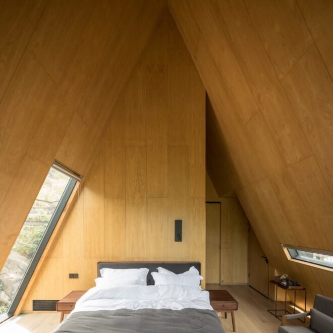 wood-lined bedroom with steeply pitched ceiling