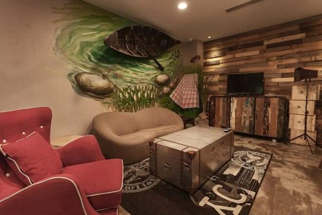 lounge area with gray sofa and red chair