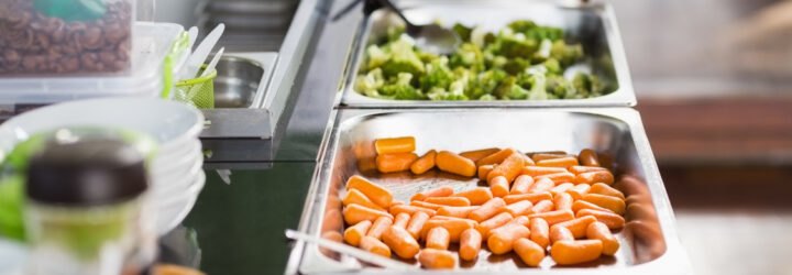 cafeteria with trays of carrots and broccoli