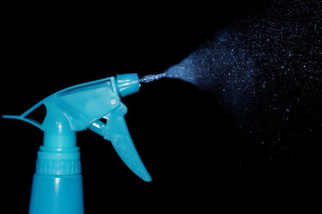 blue spray bottle on black background