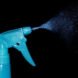 blue spray bottle on black background