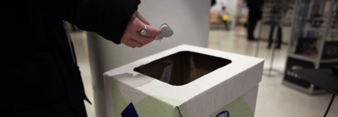 person depositing contacts in special recycling bin