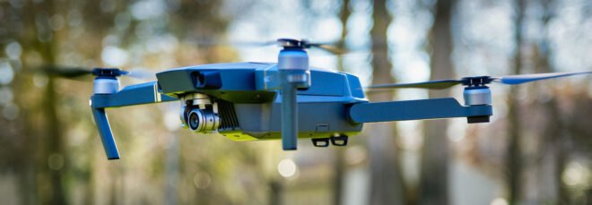 drone flying in a park filled with trees