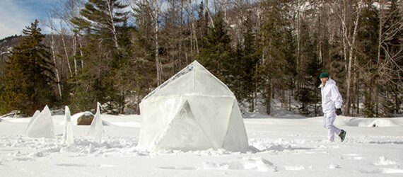 man walking toward geodesic ice igloo