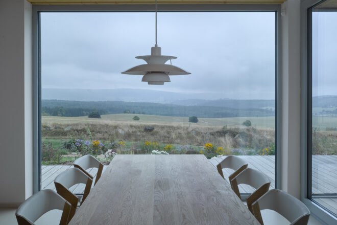 interior of home with focus on wooden dining table next to large floor to ceiling window