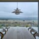 interior of home with focus on wooden dining table next to large floor to ceiling window