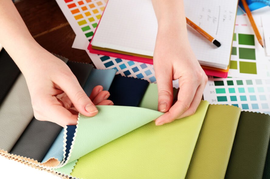person holding multiple swatches of green colored fabric