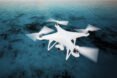 white drone flying over ocean