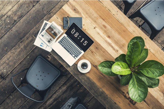 wood table with laptop and plants