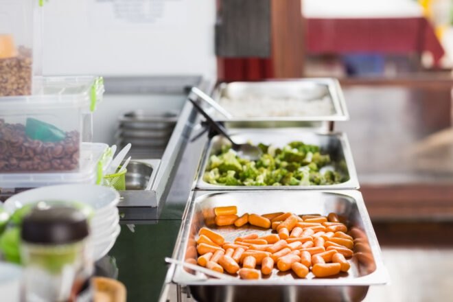 cafeteria with trays of carrots and broccoli