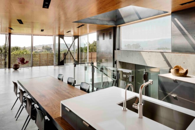 kitchen with white countertops and dark cabinets and a long wood dining table