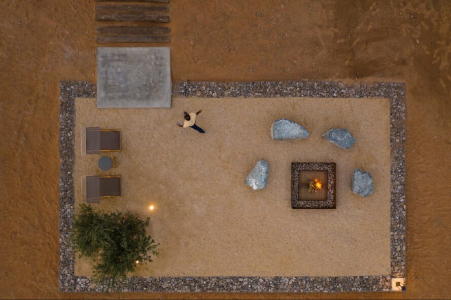 aerial shot of man walking away from fire pit