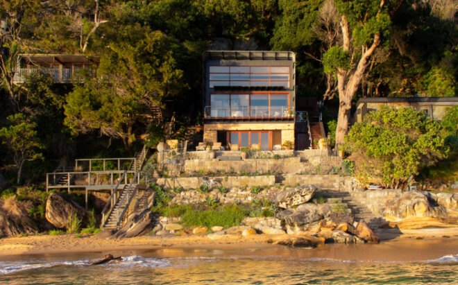 home with glass facade built on shoreline