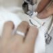 person sewing a tag onto a white bag