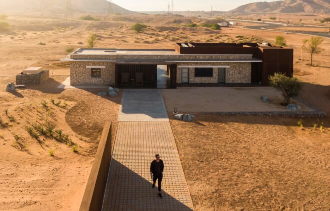 man walking down path to single-story building