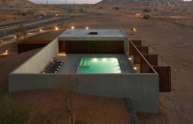 single-story building with a pool in a desert landscape