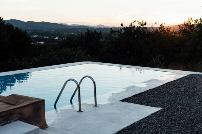 swimming pool surrounded by greenery at sunset