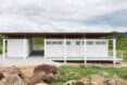white beekeepers workshop surrounded by grass