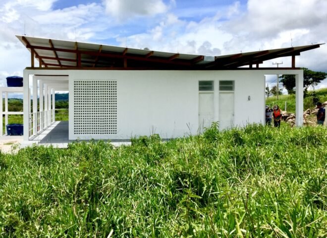 white beekeepers workshop surrounded by grass