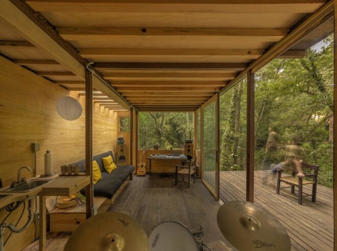 music studio with drums and couch outdoor patio and large windows