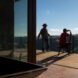 two people sitting on a large wooden deck
