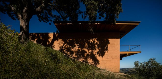 a home with an adobe wall built into a hill