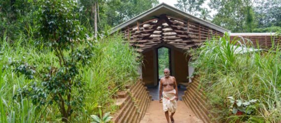 person walking in front of wood and rammed earth home