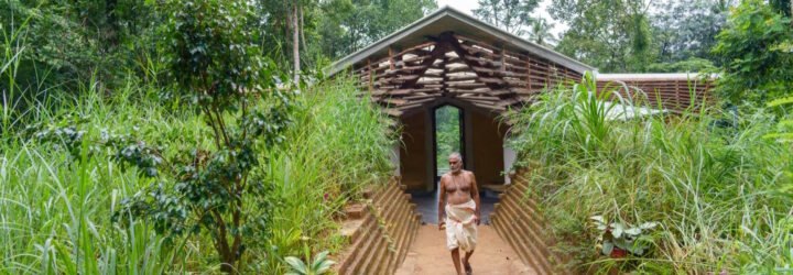 person walking in front of wood and rammed earth home