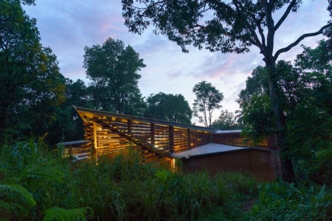 wood and rammed earth home lit up at dusk