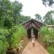 person walking in front of wood and rammed earth home