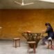 person witting at table made of tree stump and glass top