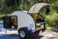 white teardrop camper with back door lifted open