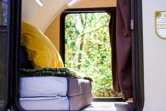 bed facing a window inside a teardrop trailer