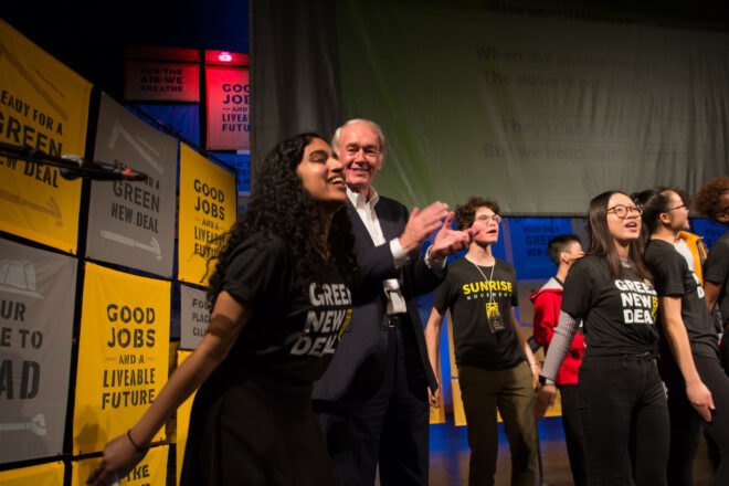 group of youth activists stand on stage during rally