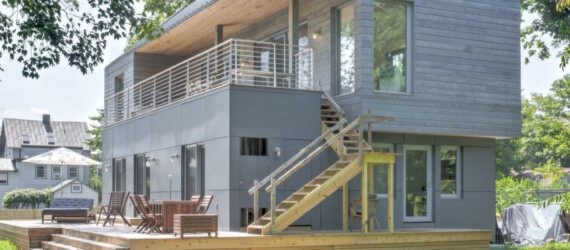 home with gray cedar siding and second-story deck