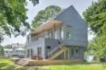 home with gray cedar siding and second-story deck