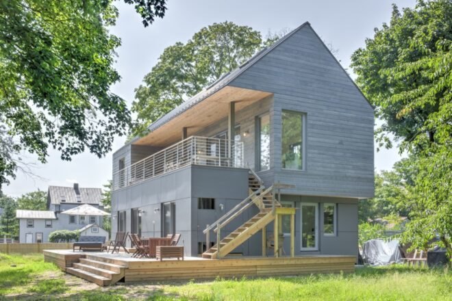 home with gray cedar siding and second-story deck