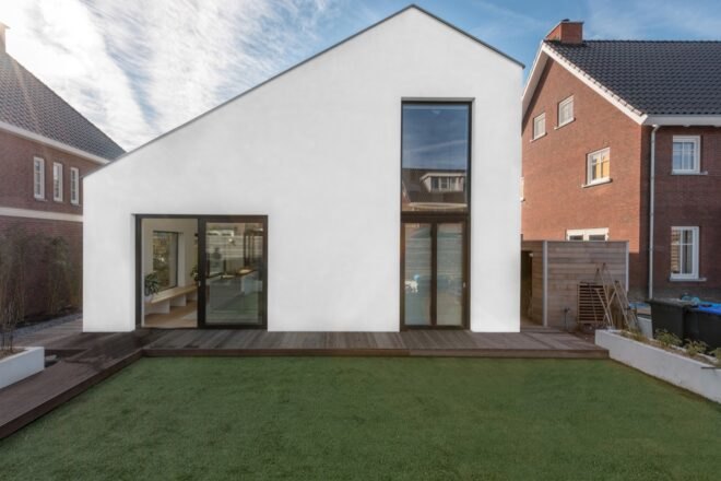 side view of the home with large windows near backyard with large portion of grass
