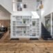wooden floors in lower level of the home with nearby staircase and white bookshelf