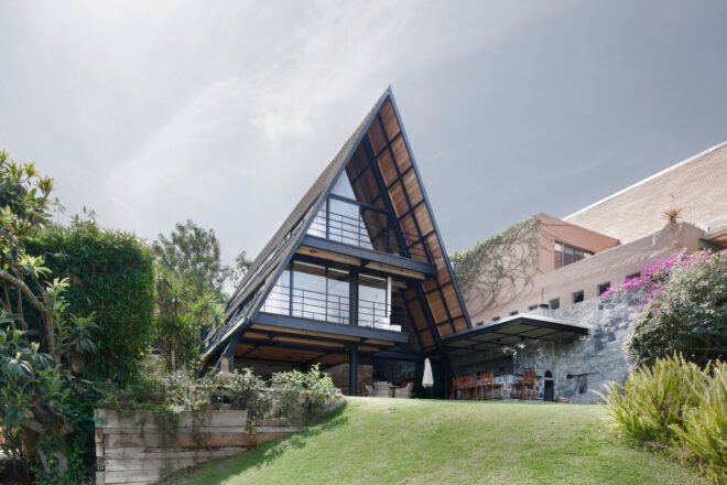 black A-frame home with glass walls