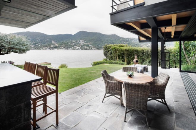 outdoor bar with stools and dining table with views of the lake