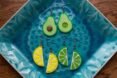 a bowl with avocado and lemon and lime earrings